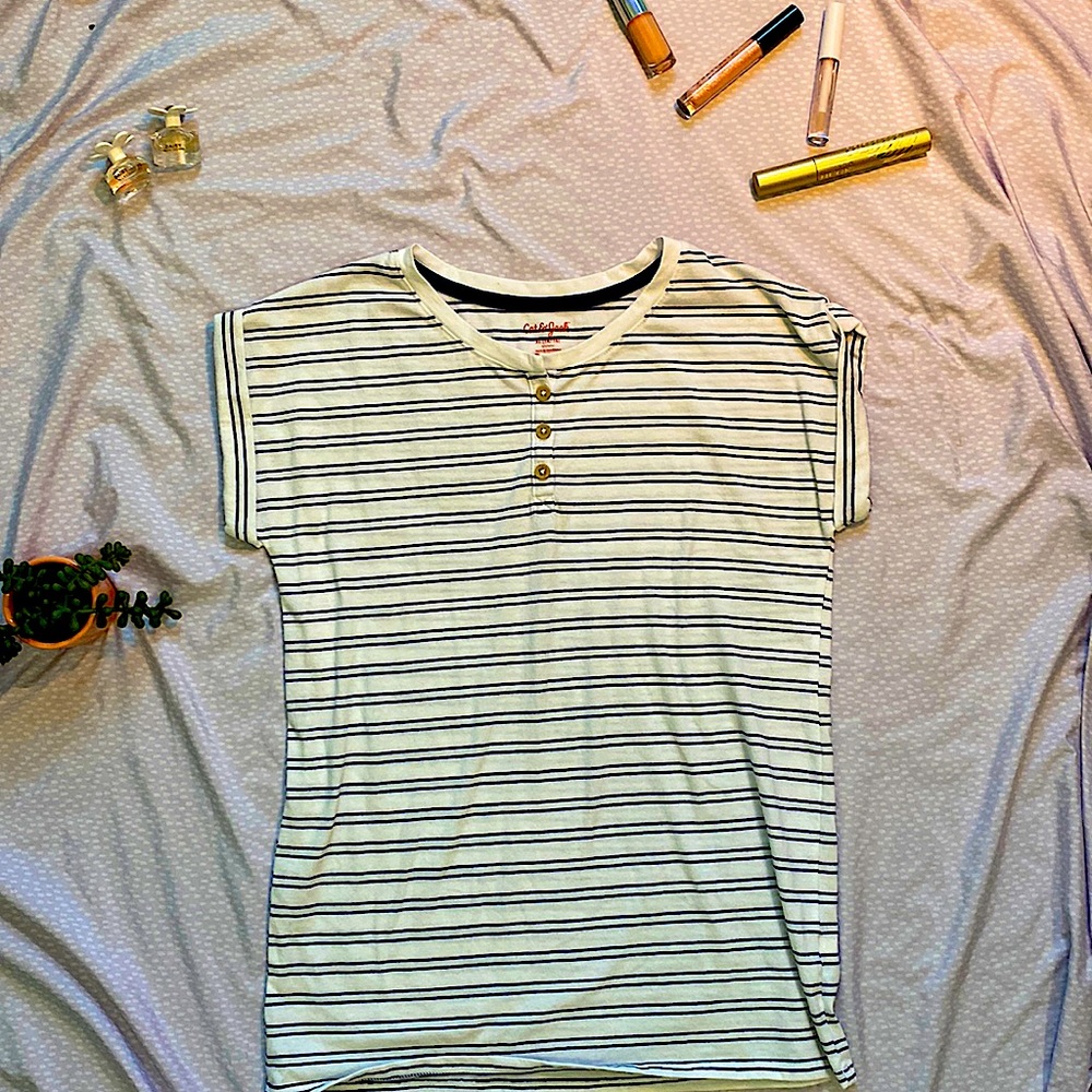 This shirt is white and blue striped. It has buttons in the front, and is comfy.
